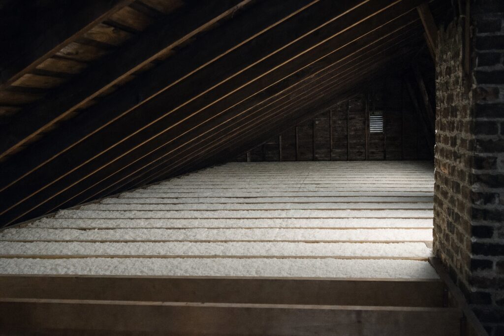 The same attic after remediation: contaminated material removed and fresh even insulation laid between clean joists.